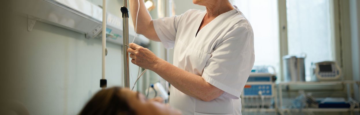 Женщина ставит капельницу пациентке